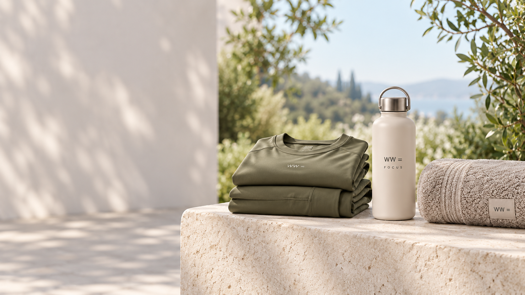 Wealth and Wellness activewear, water bottle and towel in a bright natural outdoor setting